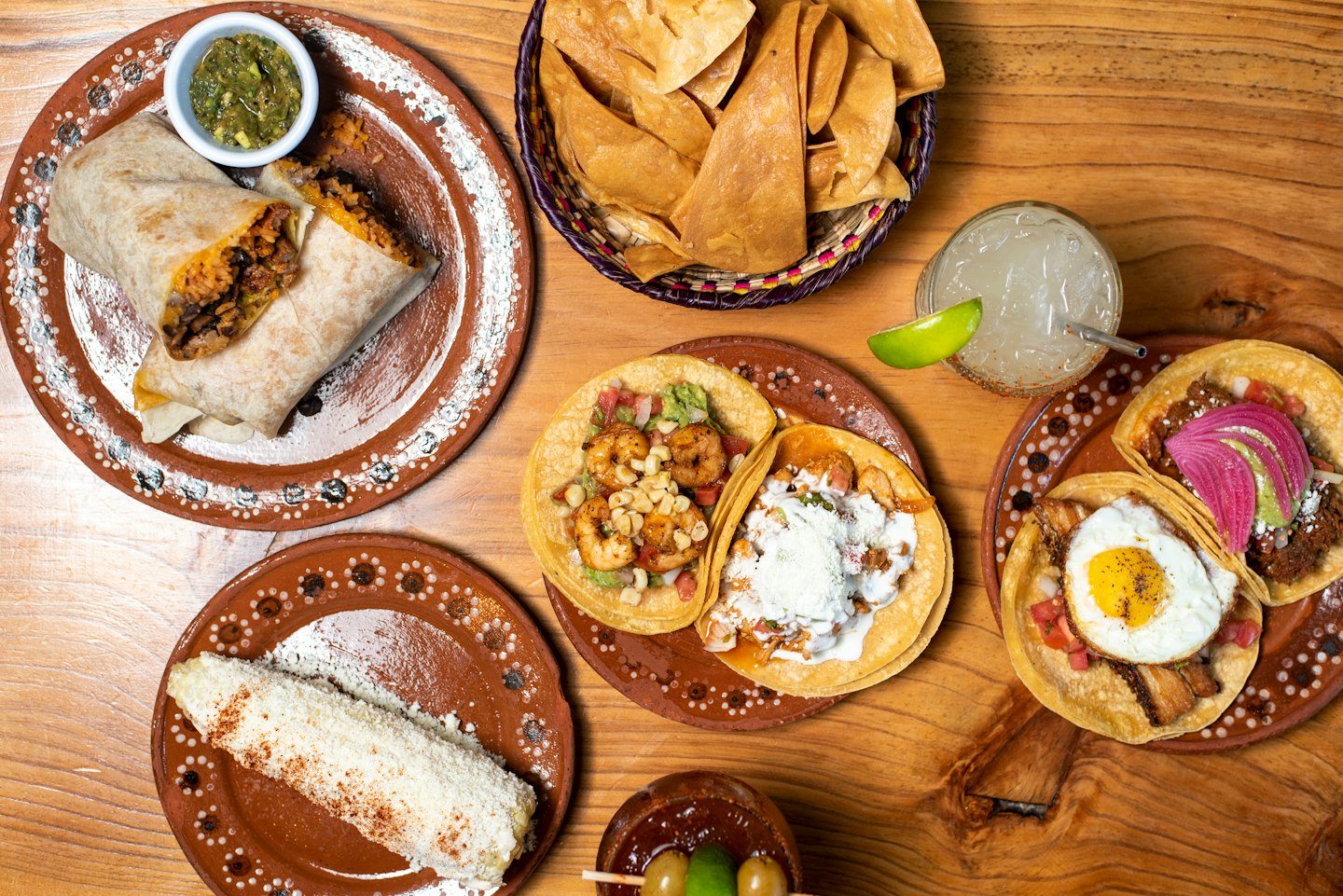 An assortment of traditional Mexican dishes served on a wooden table.