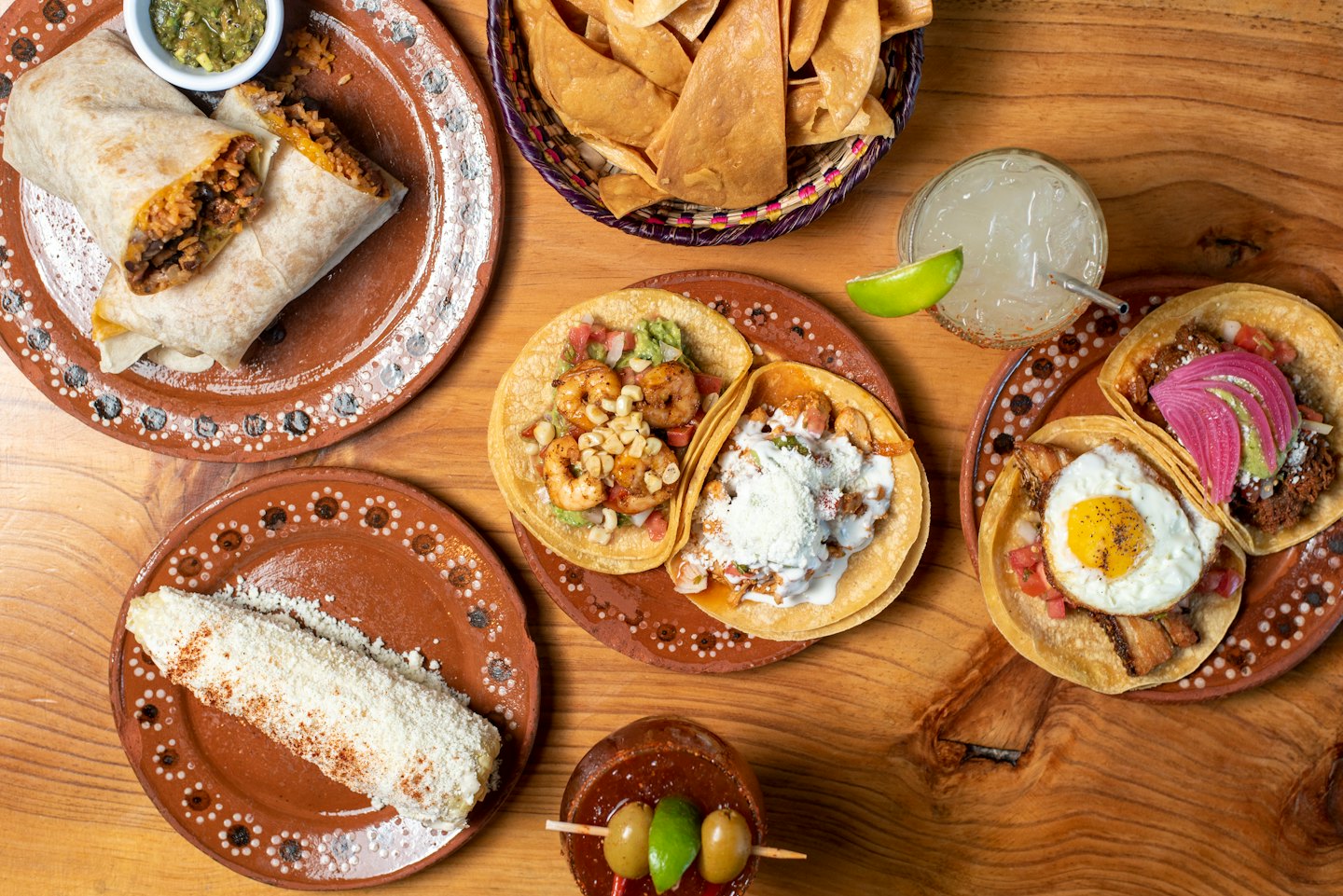 An assortment of Mexican dishes arranged on a rustic wooden table.